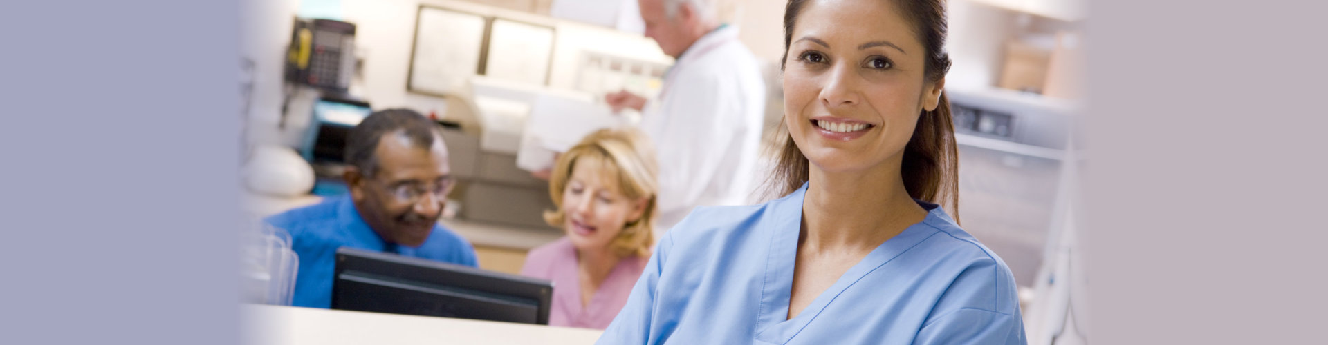 nurse smiling in front of elderly couple